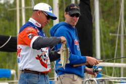 FLW Tour pro Clark Wendlandt lands a fish as NASCAR driver Kyle Busch looks on.