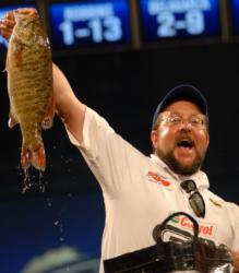 Co-angler Mark Frickman displays one of his tournament-winning smallmouth to the crowd.
