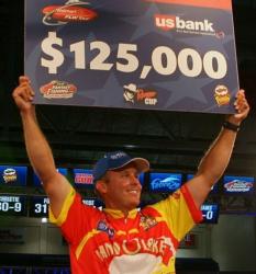 Pro Keith Williams holds up the first-place check worth $125,000.