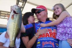 Mark Rose of Marion, Ark., shows off part of his winning 77-pound, 11-ounce catch as his family joins him onstage to celebrate victory at Pickwick Lake.