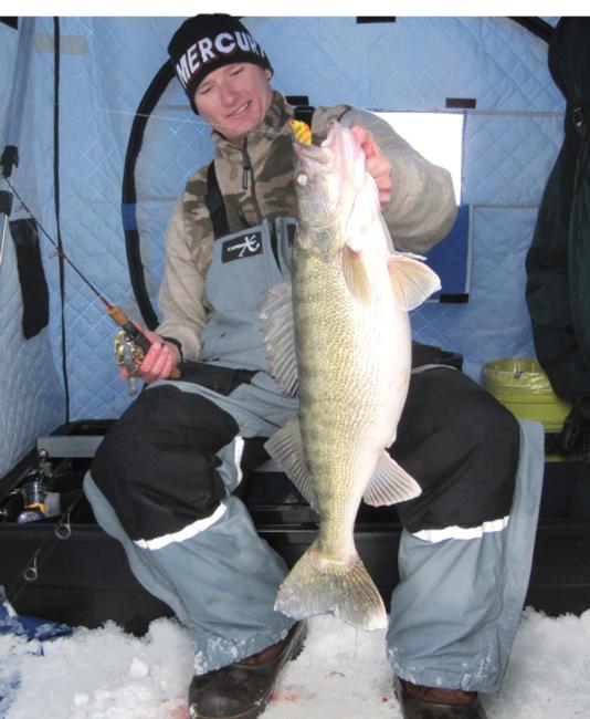 Ross Robertson pulls a large walleye through the ice with a blade bait.