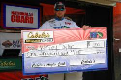 Wesley Taylor from Decherd, Tenn., holds up his Cabela's Angler Cash check during day two of TBF National Championship competition.