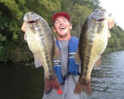 Blake Nick holds up two giant spotted bass caught on the Warrior River.