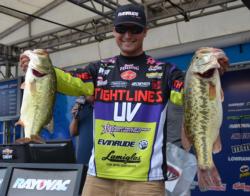 Seventh-place pro Justin Lucas holds up his two biggest bass from day one on Lake Chickamauga. 