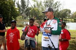 Castrol team pro Mike Surman takes some time out to help children from the local Broward County Boys and Girls clubs hone their fishing skills.