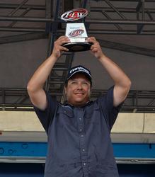 Co-angler Billy Dehart holds up his trophy for winning the FLW Tour event on Lake Okeechobee.