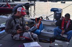 Wesley Strader shares a laugh with his co-angler while rigging up rods for the day.