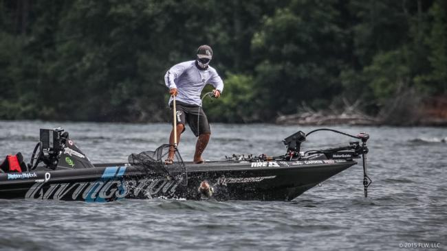 Stetson Blaylock reaches out for a frisky bass at the edge of the boat. 