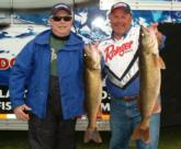 Patrick Neu and Mark Cottingham display two of their five walleyes from day one.