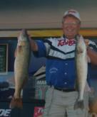 Wayne Butz, the winning pro angler, shows off two of the five walleyes he caught on day four.
