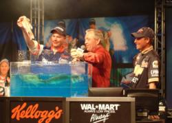 Bryan Thrift watches as pro winner Aaron Hastings places a fish on the scale.