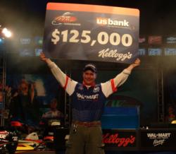 Pro Aaron Hastings shows off his first-place check for $125,000.