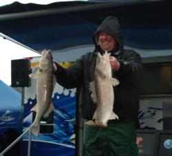 Pro Scott Banks shows off two massive Detroit River walleyes caught on day one.