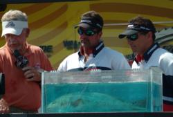 Bo Johnson and Richard Hudec stare at the scale Friday. Their two-fish limit weighed 13-1, moving them up to second place.