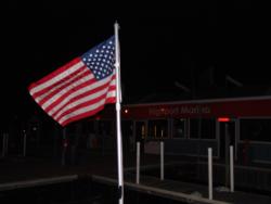The American flag whips in the puffy wind blowing across Hiport Marina.