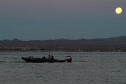 A boater heads out onto the open waters of Lake Havasu under a brilliant full moon.