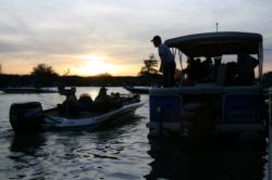 Sunrise peaks over the horizon as the FLW crew inspects tournament boats on day one.
