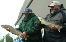 Co-angler Larry Behsman and pro Pete Harsh hold up two Cass Lake walleyes.