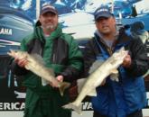 Pro Carl Adams Jr. and co-angler Chuck Jones hold up two Cass Lake walleyes.