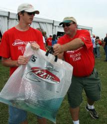 Brandon Finney of the East Tennessee Bass Club, left, takes a bag of fish from Mike Cole of the Loudoun County Bass Club.