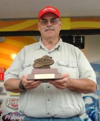 Michigan Division co-angler Tom Laveque holds up his trophy for winning the Walleye League Finals.