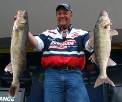 Pro Nick Johnson holds up two kickers he caught on day three of the FLW Walleye Tour qualifier on the Mississippi River.