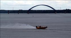 An tournament boat speeds upstream on the Mississippi River with the Highway 280 Bridge in the background.