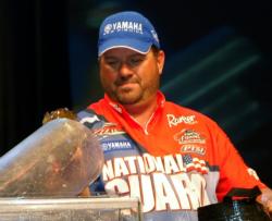 Second-place pro David Curtis places a smallmouth bass on the scale.