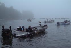 With dense flog blanketing Lake Ouachita, FLW Tour anglers carefully make their wat to the start line.