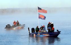 The National Guard FLW Walleye Tour start boat flies the American flag along with the National Guard flag during the national anthem on day one of the championship on the Missouri River.