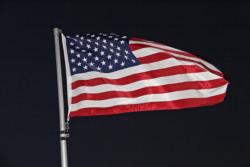 The American flag fluttered steadily in a morning breeze that will lkely strengthen as the day continues.