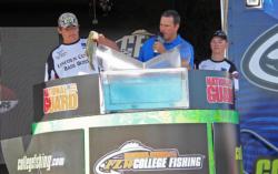 Drew Bailey loads one of the winning fish for Lincoln High School as teammate Adam Diehl looks on. 