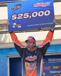 Co-angler champion Patrick Bone holds up his $25,000 check.