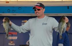 Co-angler champion Hoyt Tidwell holds up his two biggest bass from day three on Smith Lake.
