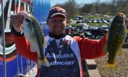 Second-place co-angler Steven Meador holds up a spotted bass and a smallmouth bass.