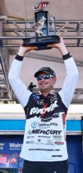 Jason Christie of Park Hill, Okla., hoists his first-place trophy over his head shortly after securing victory at the FLW Tour event on Grand Lake.