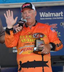 Co-angler champion Jerry Reagan acknowledges the crowd and displays his trophy.