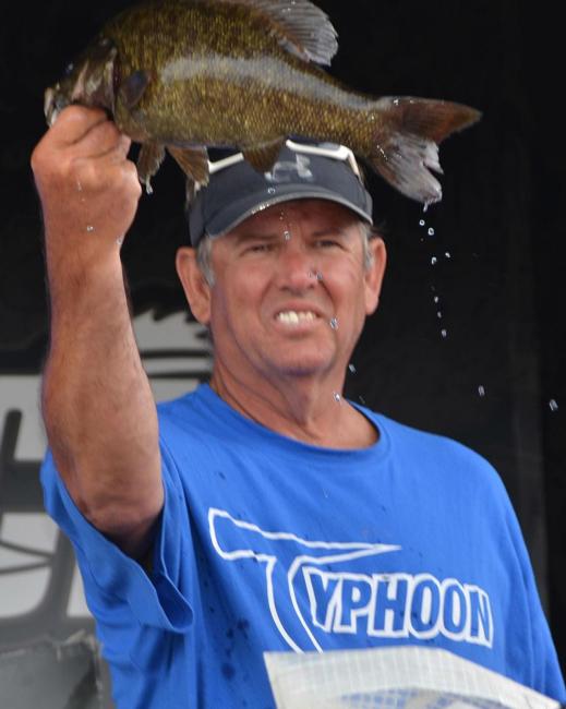 Third-place co-angler Donald Sibley holds up a smallmouth bass. 